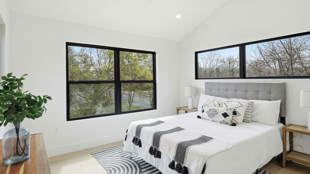 Bedroom with light wood-type flooring, vaulted ceiling, and recessed lighting
