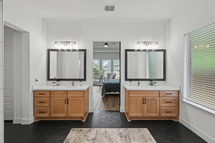 The bathroom has dual maple stained cabinets, upgraded quartz counter tops with undermount sinks and brushed nickel faucets. The black framed mirrors coordinate well with the cabinet hardware and the light fixtures were upgraded. These vanities not only have undercounter storage but drawers for storage. The bathroom has dual maple stained cabinets, upgraded quartz counter tops with undermount sinks and brushed nickel faucets. The black framed mirrors coordinate well with the cabinet hardware and the light fixtures were upgraded. These vanities not only have undercounter storage but drawers for storage.