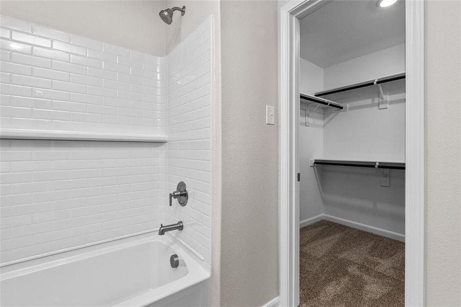 Bathroom featuring shower / bath combination and a walk in closet Bathroom featuring shower / bath combination and a walk in closet