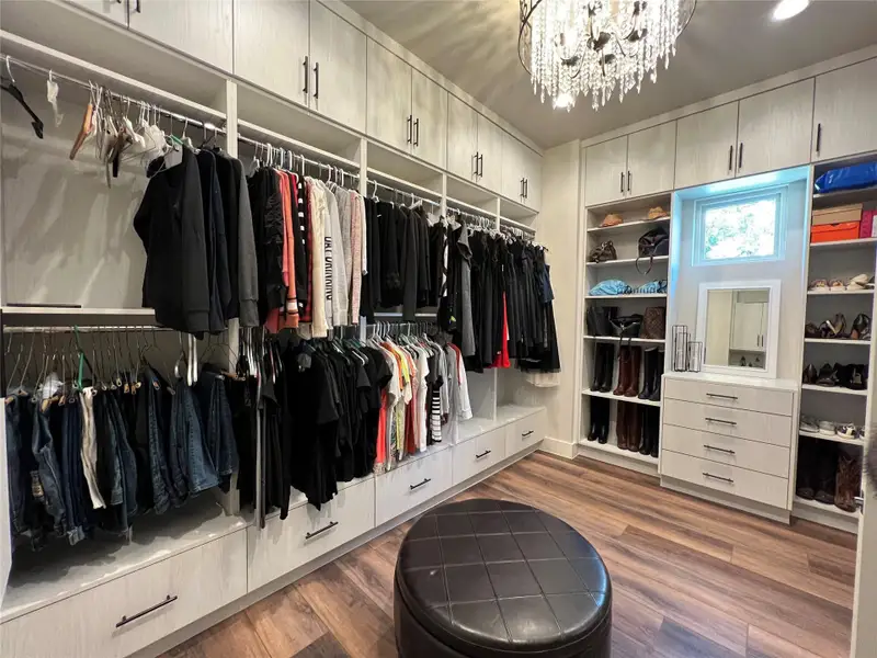Spacious her's closet with chandelier and built ins Spacious her's closet with chandelier and built ins
