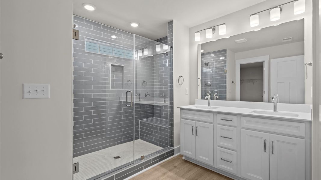 Notable primary suite with dual vanities and walk-in shower in this prime Greenville townhome