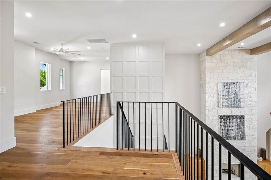 Second floor landing, iron railing overlook, board and batten accent wall, hardwood floors Second floor landing, iron railing overlook, board and batten accent wall, hardwood floors