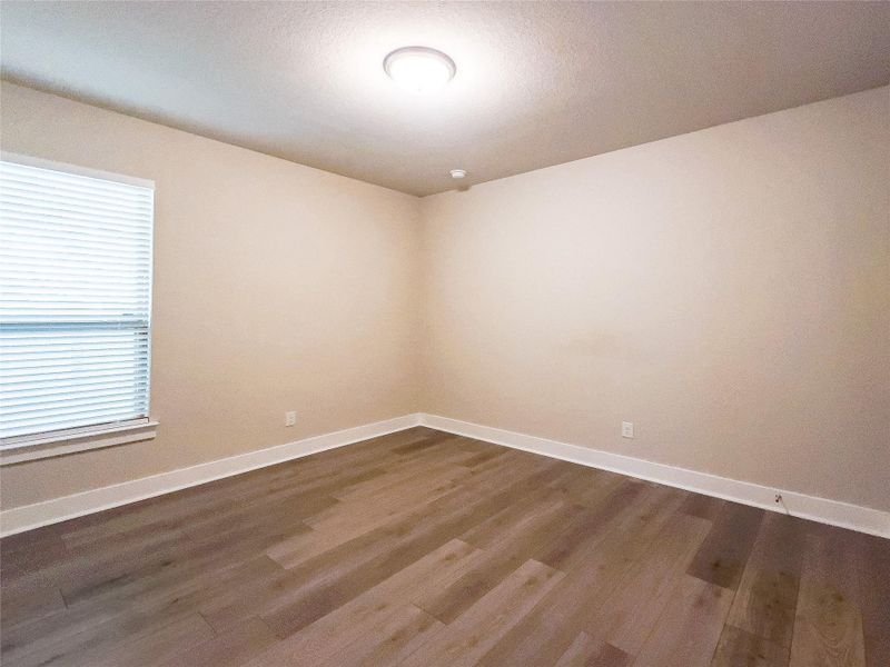 Spare room with dark wood-style flooring and a textured ceiling Spare room with dark wood-style flooring and a textured ceiling