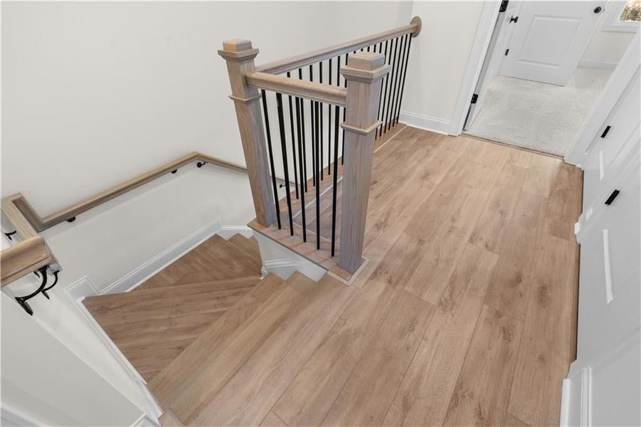 Stairway featuring wood finished floors and baseboards