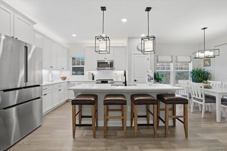 The kitchen island has bar seating and beautiful pendant lights.