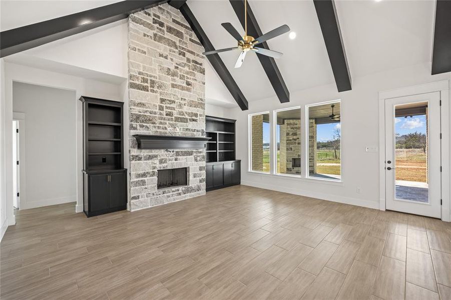 Unfurnished living room with a fireplace, wood finish floors, a ceiling fan, lofted ceiling, and recessed lighting