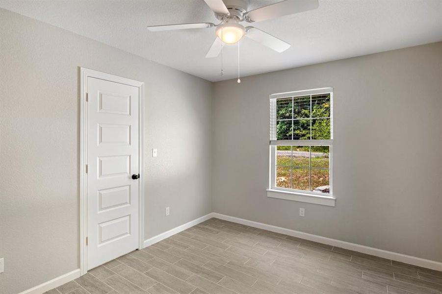 Unfurnished room featuring wood finish floors and ceiling fan Unfurnished room featuring wood finish floors and ceiling fan