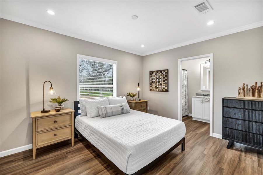 Bedroom featuring crown molding, dark wood-style flooring, recessed lighting, and ensuite bathroom