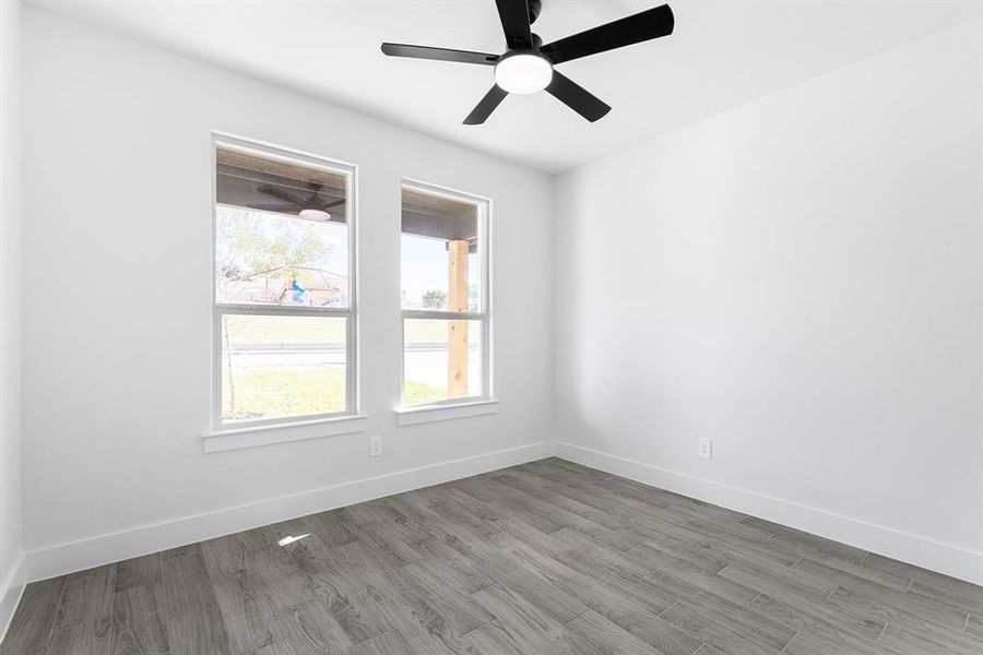 Empty room with wood-type flooring and ceiling fan