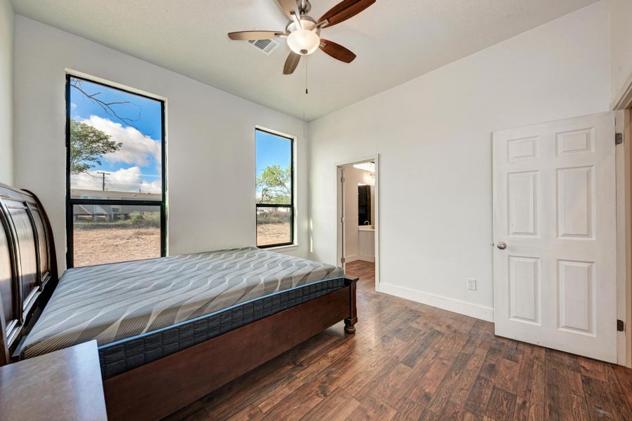 Rich wood floors and tall windows define this peaceful bedroom retreat.