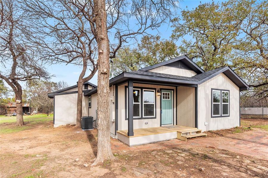 View of front of home featuring roof with shingles and a deck