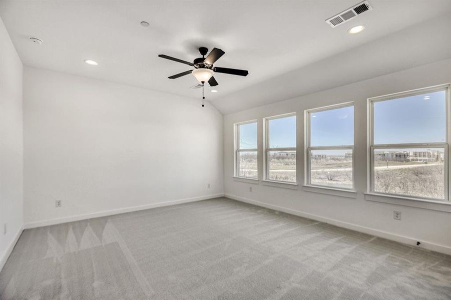 Empty room featuring vaulted ceiling, ceiling fan, light colored carpet, and recessed lighting