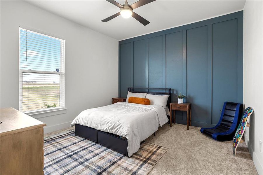 Carpeted bedroom featuring ceiling fan