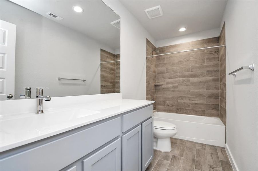 Secondary bath equipped with shower/tub combo.