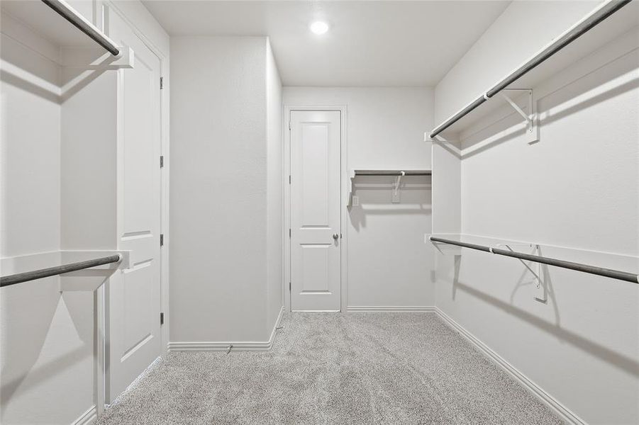 Walk in closet featuring light colored carpet Walk in closet featuring light colored carpet