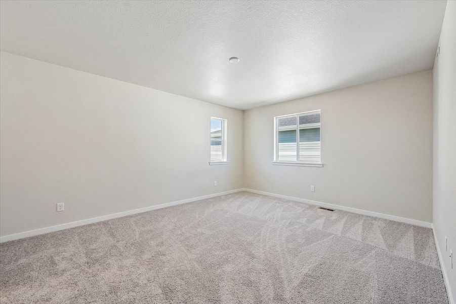 A room with a carpet and a window.