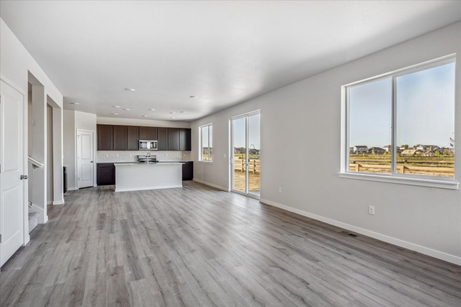 A large empty room with a wood floor and a large window. A large empty room with a wood floor and a large window.