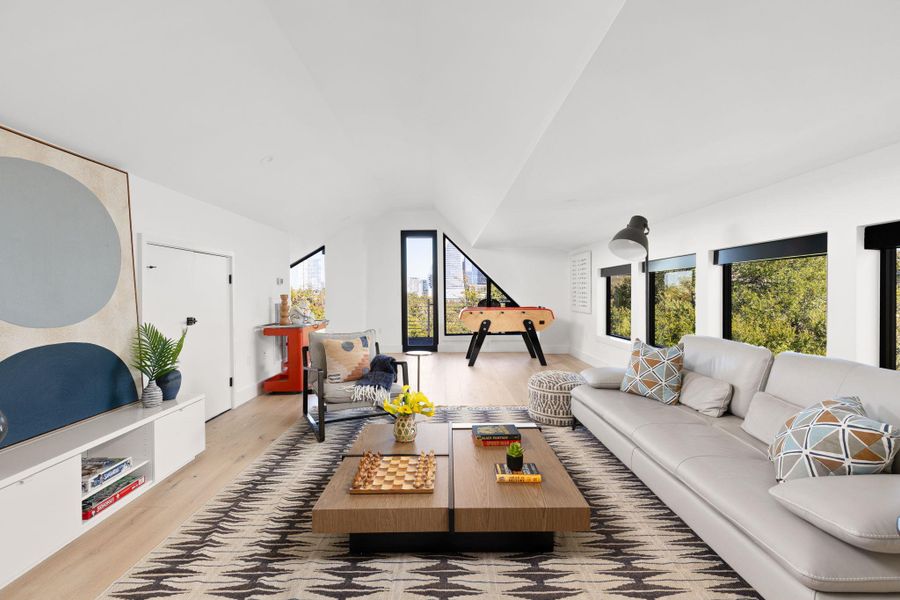 Living area with light wood-type flooring and vaulted ceiling Living area with light wood-type flooring and vaulted ceiling