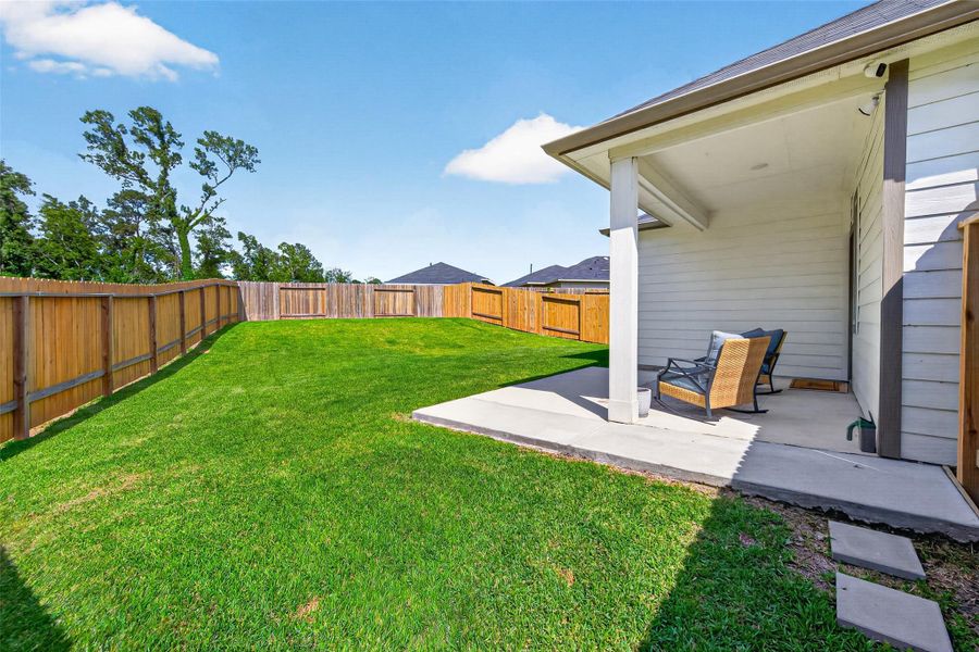 Spacious backyard with lush green grass, fenced for privacy. Includes a covered patio area perfect for outdoor relaxation or entertaining. Spacious backyard with lush green grass, fenced for privacy. Includes a covered patio area perfect for outdoor relaxation or entertaining.