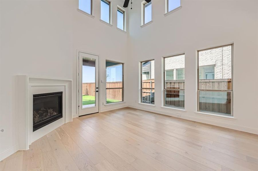 Unfurnished living room featuring ceiling fan and light hardwood / wood-style flooring