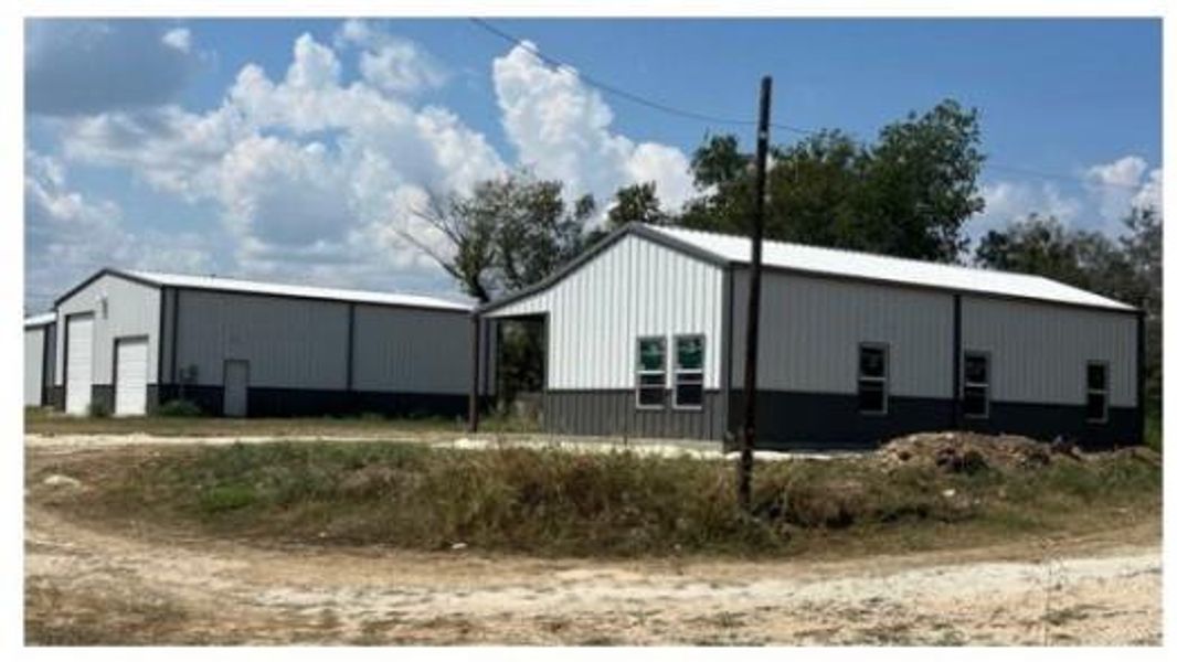 View of side of home featuring an outdoor structure, a garage, and an outbuilding View of side of home featuring an outdoor structure, a garage, and an outbuilding