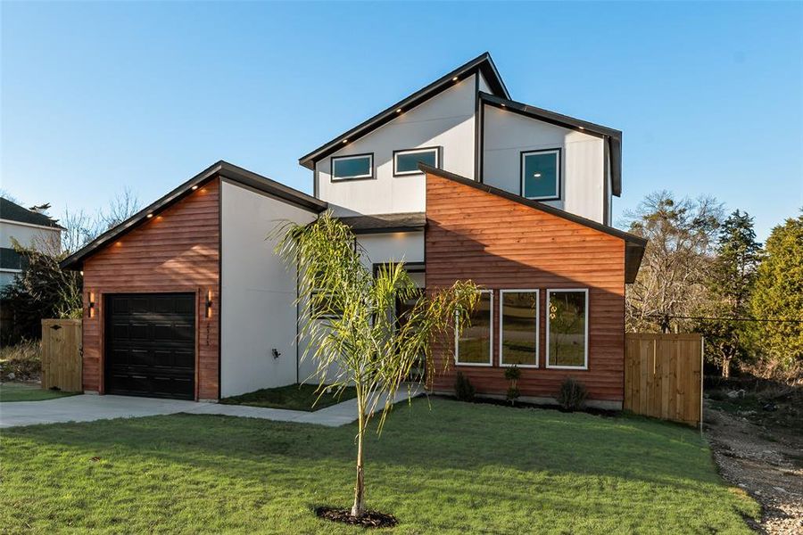 Modern home featuring a garage and driveway Modern home featuring a garage and driveway