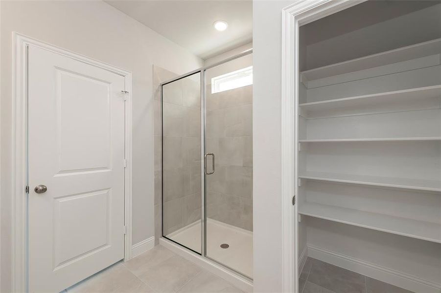 Full bathroom with a shower stall, tile patterned flooring, and baseboards Full bathroom with a shower stall, tile patterned flooring, and baseboards