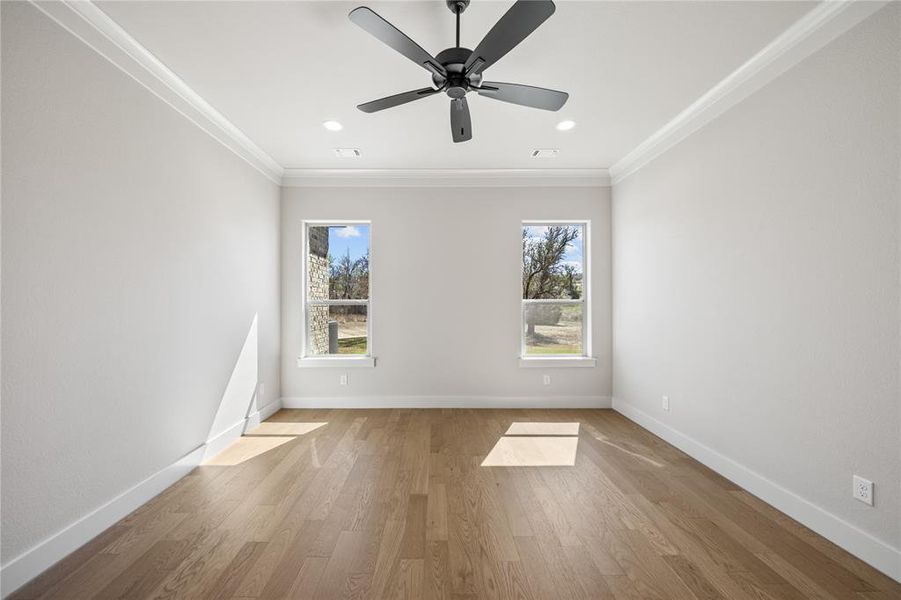 Empty room featuring crown molding, light wood-style floors, ceiling fan, healthy amount of natural light, and recessed lighting