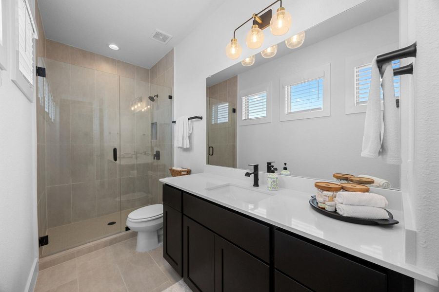Full bath with healthy amount of natural light, vanity, a shower stall, tile patterned floors, and recessed lighting