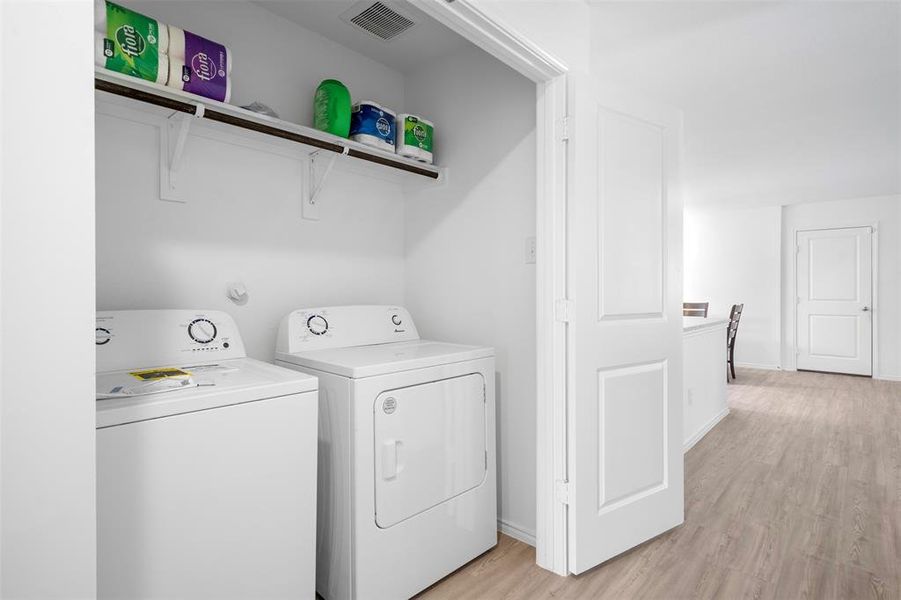 Laundry area featuring light wood finished floors and washing machine and clothes dryer Laundry area featuring light wood finished floors and washing machine and clothes dryer