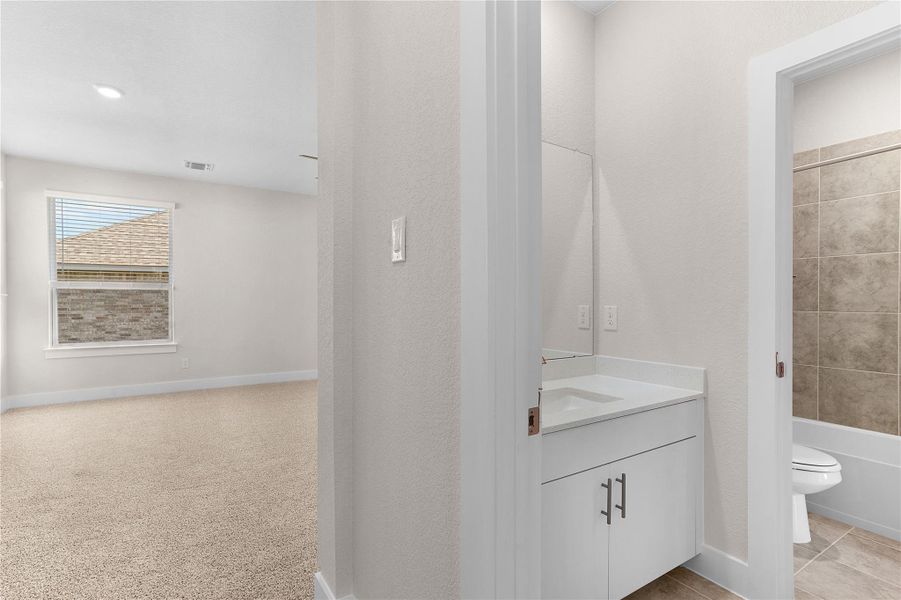 Bathroom featuring vanity, toilet, shower / washtub combination, and baseboards