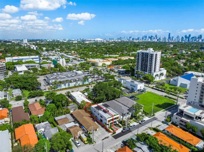 Aerial perspective of a multi-story residence featuring a flat roof with solar panels, a private rooftop deck, and balcony enclosures with horizontal slat privacy screening Aerial perspective of a multi-story residence featuring a flat roof with solar panels, a private rooftop deck, and balcony enclosures with horizontal slat privacy screening