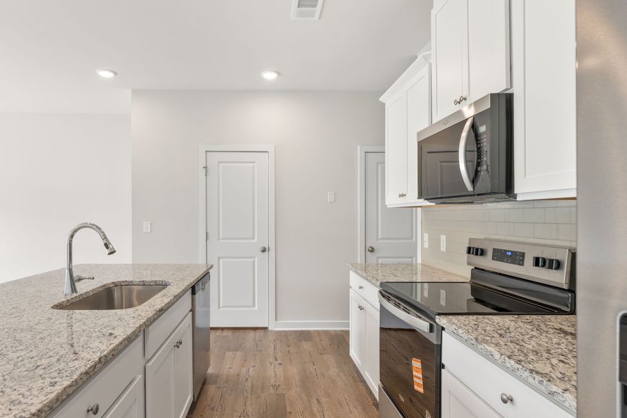 A kitchen with white cabinets.