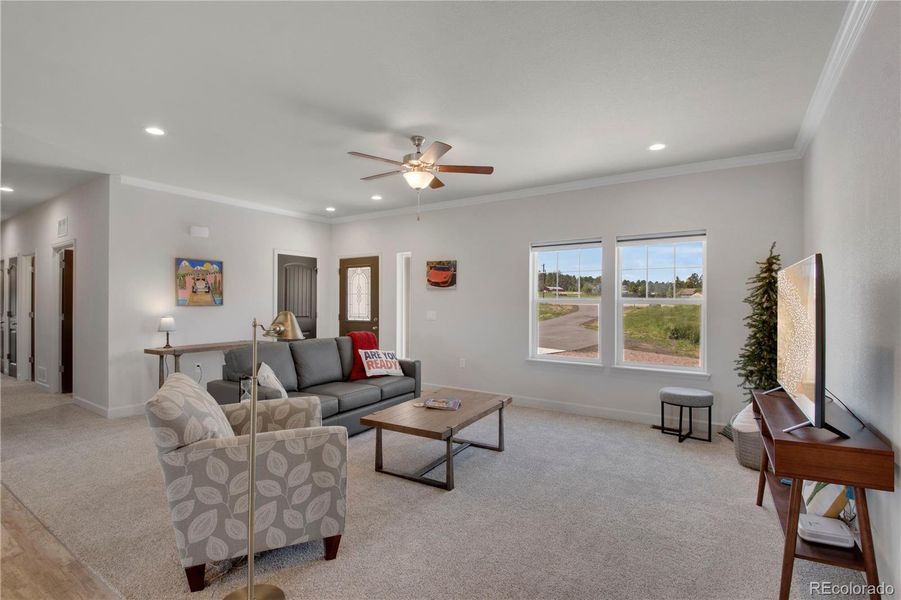 Living room with recessed lighting, ornamental molding, a ceiling fan, open concept
