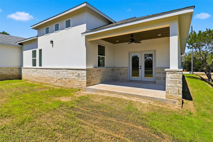 Exterior featuring a covered patio with wood-finish ceiling, ceiling fan, and stone-clad columns Exterior featuring a covered patio with wood-finish ceiling, ceiling fan, and stone-clad columns
