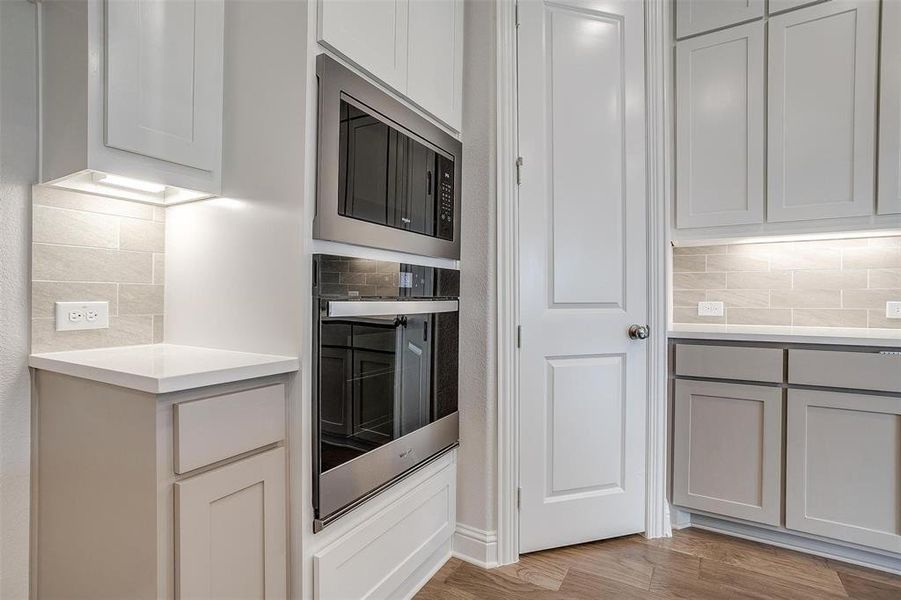 Kitchen featuring decorative backsplash, stainless steel appliances, and light hardwood / wood-style floors