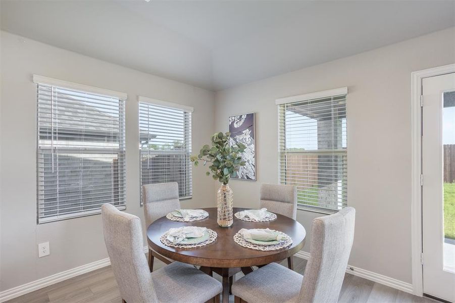 Dining space featuring light wood-type flooring and healthy amount of natural light Dining space featuring light wood-type flooring and healthy amount of natural light