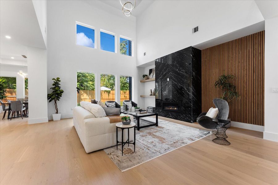 Spacious and inviting living room featuring high ceilings, abundant natural light, and a sleek modern fireplace. Perfect for relaxation or entertaining. Spacious and inviting living room featuring high ceilings, abundant natural light, and a sleek modern fireplace. Perfect for relaxation or entertaining.
