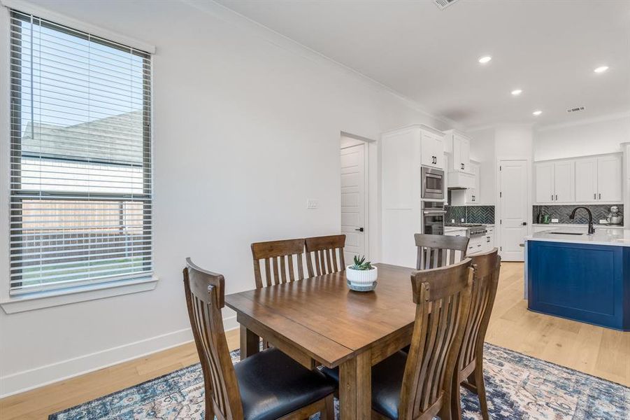 Dining room featuring crown molding, light hardwood / wood-style flooring, and sink