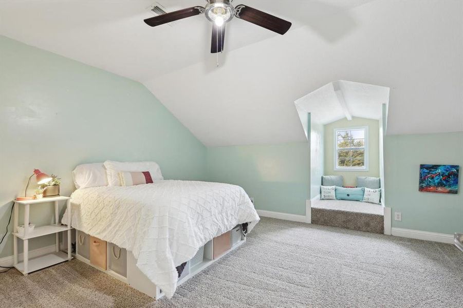 Bedroom featuring vaulted ceiling, light colored carpet, and ceiling fan