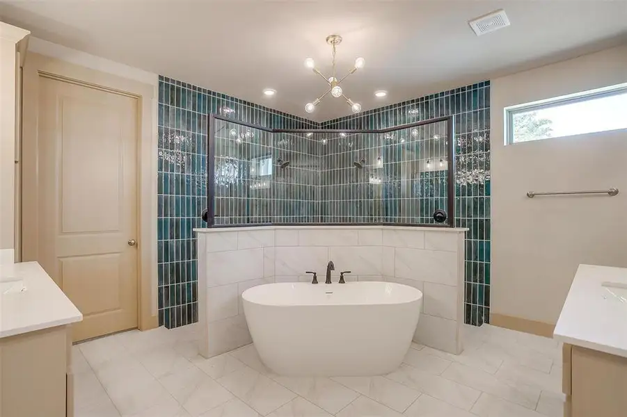 Bathroom featuring tile walls, visible vents, a walk in shower, and vanity