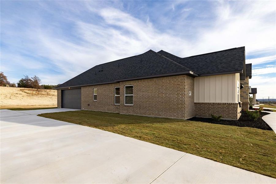 View of property exterior with a garage and a yard