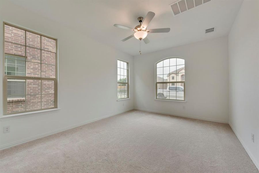 Carpeted empty room featuring ceiling fan