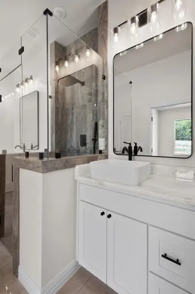 Full bathroom with a stall shower, vanity, and tile patterned floors