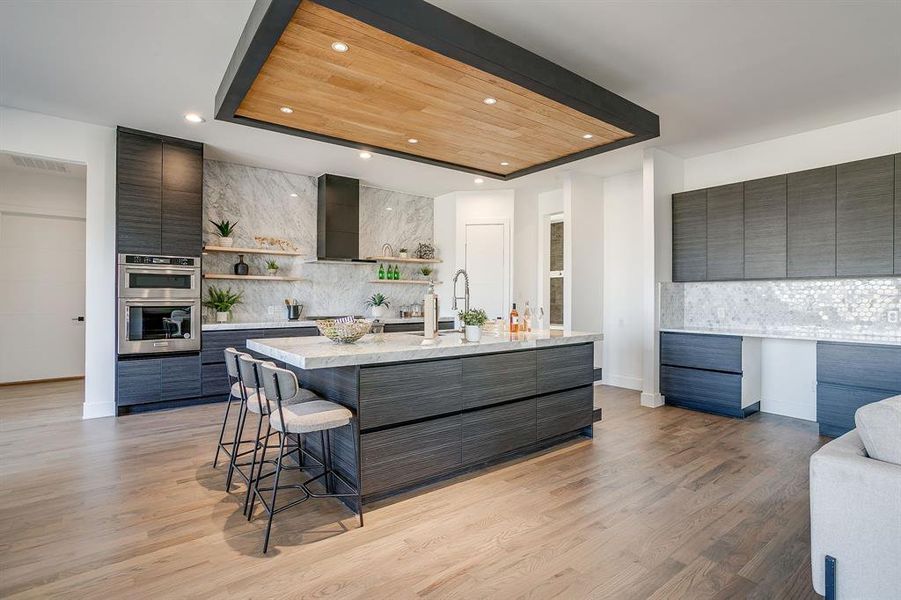 Kitchen with decorative backsplash, modern cabinets, open shelves, a kitchen bar, and recessed lighting Kitchen with decorative backsplash, modern cabinets, open shelves, a kitchen bar, and recessed lighting