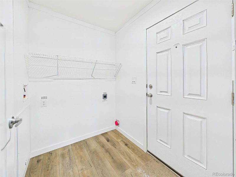 Convenient side entry with washer/dryer hookups, storage shelving, and easy access to the rest of the home.