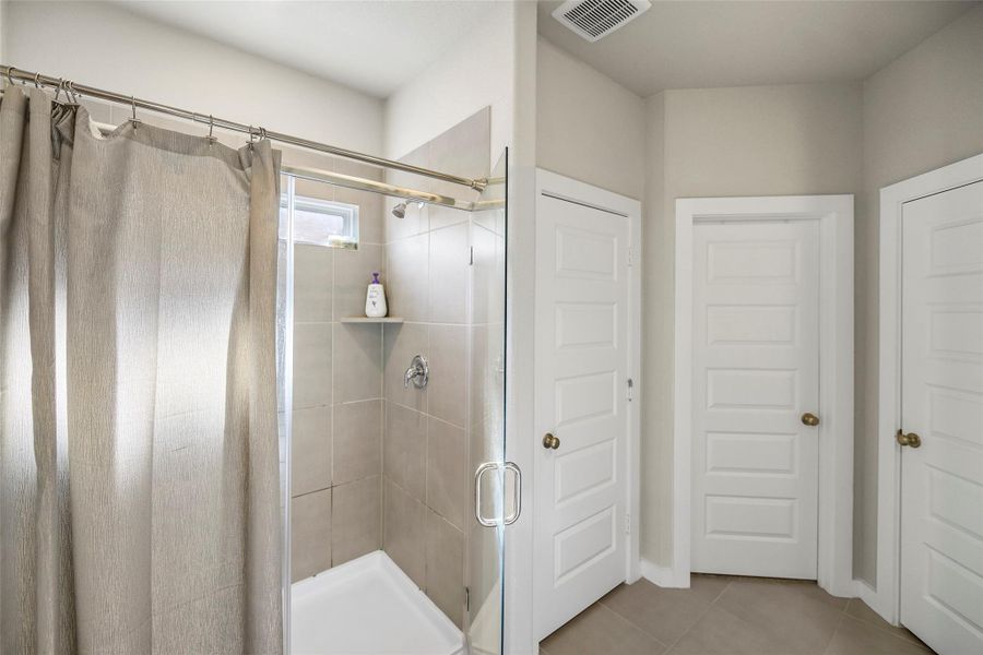 The bathroom features a modern walk-in shower.