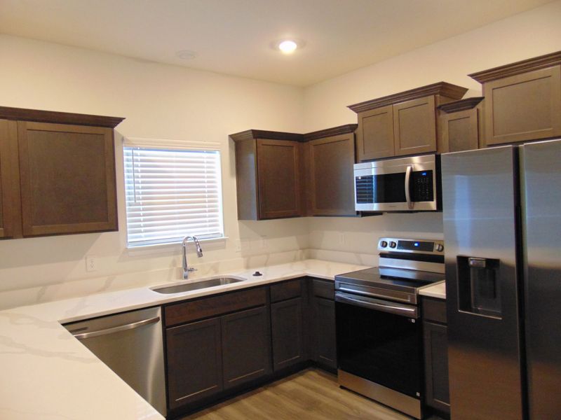 This is a sleek and modern kitchen to cook your family meals has stainless steel appliances and staggered cabinetry, as well as dreamy crowns