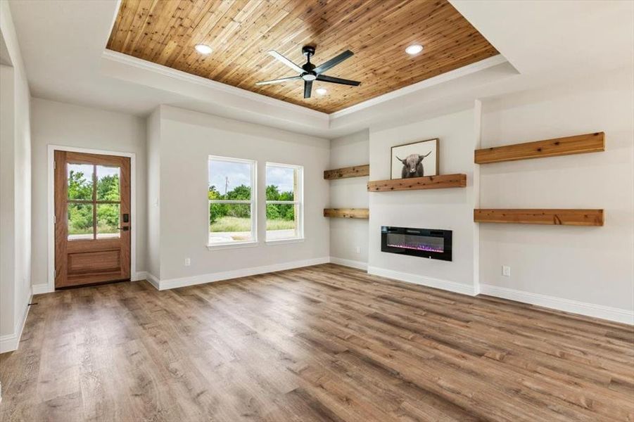 Living space featuring a tray ceiling with wood-plank finish and recessed lighting