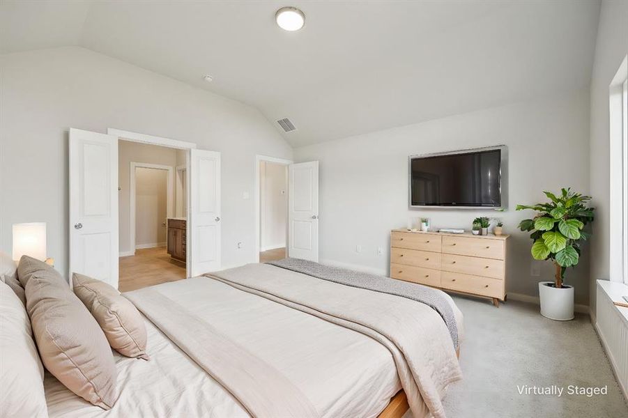 Bedroom featuring Vaulted ceiling, light carpet,